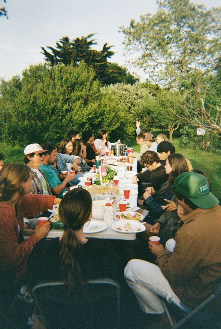 Community of people around a table outside having fun